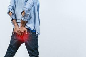 Man with digestive problem touching his buttock, man with hemorrhoid problem on isolated background, Man with diarrhea problem photo