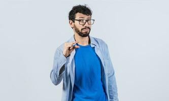 hombre demostración un pequeño cantidad con su dedos, joven hombre gesticulando con su mano demostración alguna cosa pequeño Talla con su dedos. persona medición alguna cosa con dedos foto