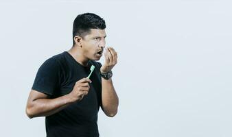 persona con cepillo con malo aliento problema, hombre con cepillo y malo aliento, concepto de persona con halitosis foto