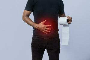 People with stomach problems holding toilet paper, Person with toilet paper with stomach problems on isolated background, Concept of a person with digestive problems photo