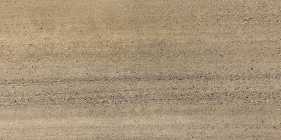 panorama of road from above on surface of gravel road with car tire tracks in countryside photo