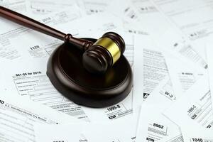 Tax forms with judges gavel on the wooden desk. Business and judgement photo