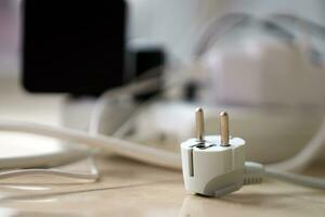 Overloaded power boards. Power strips with different electrical plugs on white floor photo