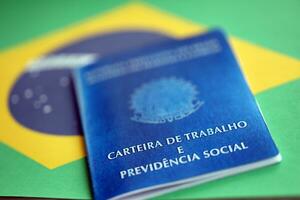 Brazilian work card and social security blue book on flag of Federative Republic of Brazil photo