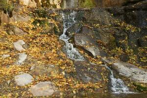 hermosa cascada Entre grande rocas en otoño bosque. sofievskiy parque en humano, Ucrania foto