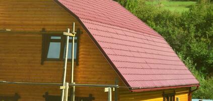 House with a roof made of solid metal sheets, shaped like an old tile photo