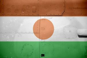 Niger flag depicted on side part of military armored helicopter closeup. Army forces aircraft conceptual background photo