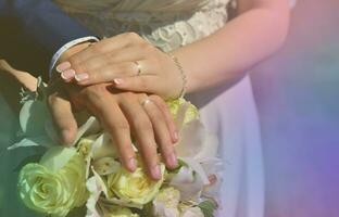 The newlywed couple is holding a beautiful wedding bouquet. Classical wedding photography, symbolizing unity, love and the creation of a new family photo