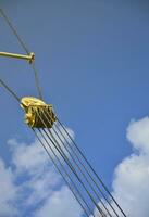 Coil for the iron cable in the tower crane against the blue sky. Mechanical component for crane operation photo