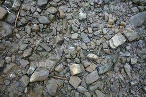 antecedentes de destrozado pedregoso piedras superficie en montaña área. textura con natural ligero foto