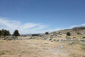 ANTALYA, TURKEY - MAY 15, 2021 Ruins of ancient city Hierapolis near Pamukkale, Turkey at sunny day. Parts of old historical buildings with big blocks photo