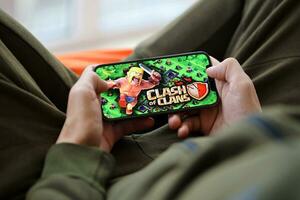Clash of Clans mobile iOS game on iPhone 15 smartphone screen in male hands during mobile gameplay photo