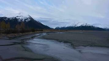 Car on Seward Highway, River and Snow-Capped Mountains on Autumn Day. Alaska, USA. Aerial View. Drone Flies Forward and Upwards over the River video