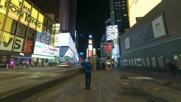 NEW YORK CITY, USA - JANUARY 23, 2021 Lonely Man Wearing Mask and Using Smartphone Standing Still at Times Square at Night During Coronavirus Pandemic. Cars Traffic and People. Time Lapse. video