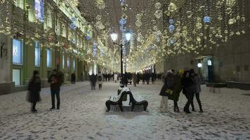 Moscou, Russie - décembre 25, 2020 temps laps de illuminé Nikolskaïa piéton rue. en marchant gens dans hiver soir. Noël vacances. Moscou, Russie. video