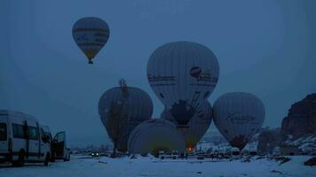 Kappadokien, Kalkon - april 10, 2021 varm luft ballonger är tar av i snöig cappadocia i vinter- morgon. Kalkon. video