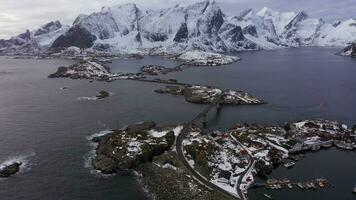 hamnoy village et montagnes dans l'hiver. norvégien mer et orageux ciel. moscènes, lofoten îles, paysage de Norvège. aérien voir. drone mouches de côté, inclinaison en haut. révéler coup video