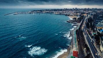 Aerial drone view of Marginal Avenue and coastline with looking west towards Cascais on a cloudy autumn day photo