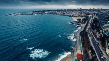 aéreo zumbido ver de marginal avenida y línea costera con mirando Oeste hacia Cascais en un nublado otoño día foto