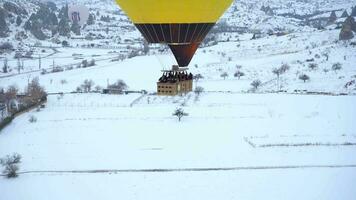 cappadoce, dinde - avril dix, 2021 air chaud ballon panier avec gens dans neigeux la cappadoce dans hiver Matin. Turquie. aérien voir. video