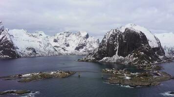 hamnoy pescar pueblo y montañas en invierno. lofoten islas, paisaje de Noruega. aéreo vista. zumbido moscas oblicuo y hacia arriba video