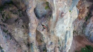 Mann Bergsteiger Felsen Klettern im Helm. Klippen von geyikbayiri, Antalya, Truthahn. Antenne Sicht. Drohne fliegt nach unten, Neigung hoch. Kran Schuss video