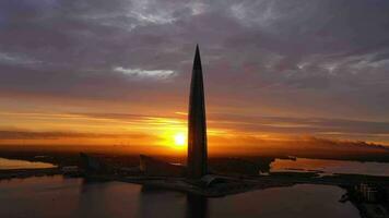 SAINT-PETERSBURG, RUSSIA - JUNE 20, 2019 Lakhta Center Tower Silhouette at Sunset. Aerial View. Russia. Colourful Sky and the Sun. Drone Flies Upwards video