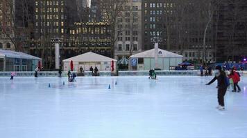 ny york stad, USA - januari 23, 2021 människor bär masker skridskoåkning på isbana på bryant parkera i manhattan på vinter- dag. video