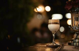 Cafe latte macchiato layered,Glass of coffee cup on  wooden table with blurry light background,Hot drink for celebration in Autumn,Winter,Beverages on Christmas,New year holiday event photo