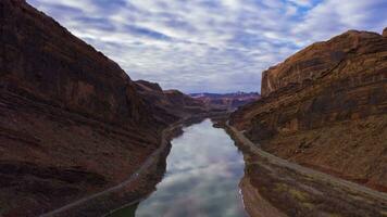 Colorado río y rojo arenisca montañas en nublado Mañana. cielo reflexión en agua. grandioso condado, Utah, EE.UU. aéreo hiper lapso, hora lapso. zumbido moscas adelante y hacia arriba video