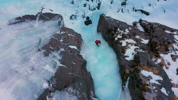 la glace escalade sur congelé cascade, aérien de haut en bas voir. Barskoon vallée, Kirghizistan. drone mouches de côté video