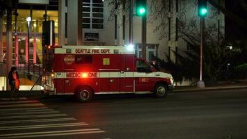 Seattle, USA - - Februar 4, 2021 Seattle Feuer Abteilung, Medizin einer Krankenwagen Fahrzeug beim Nacht mit blinkt Beleuchtung. Menschen tragen Masken video