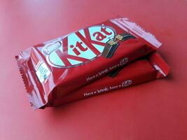 KHARKIV, UKRAINE - JANUARY 2, 2021 Kit Kat by Nestle chocolate covered wafer on bright color photo