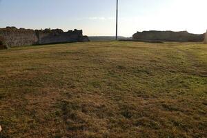 TERNOPIL, UKRAINE - SEPTEMBER 16, 2023 Scenic view of ruins of an ancient Kremenets castle. Ternopil region, Ukraine. Gate tower and part of defensive wall on Bona mountain photo