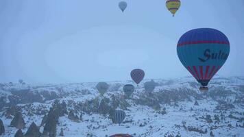 cappadoce, dinde - avril dix, 2021 air chaud des ballons dans neigeux la cappadoce dans hiver Matin. Turquie. aérien voir. video