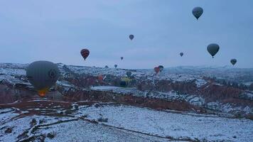 CAPPADOCIA, TURKEY - APRIL 10, 2021 Hot-air balloons in Snowy Cappadocia in Winter Morning. Turkey. Aerial View. Drone Flies Upwards. video