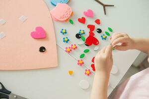 un blogger niña hace un sintió arte para San Valentín día en el forma de un corazón. el concepto de para niños creatividad y hecho a mano. foto