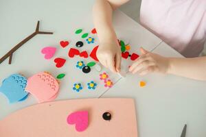 un blogger niña hace un sintió arte para San Valentín día en el forma de un corazón. el concepto de para niños creatividad y hecho a mano. foto