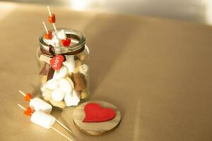 sweet gift for Valentine's Day with your own hands. A gift for the holiday made of heart-shaped candies and marshmallows photo