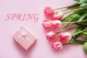 Pink Tulip flowers are arranged on a pink background. The view from the top, flat lay. Empty space for the text. Spring concept. Women's day. Mother's day. photo