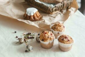 Easter cupcakes with raisins and quail eggs on a white table close-up. The concept of celebrating Happy Easter. photo