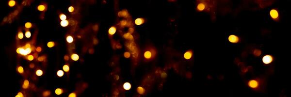 Blurry garland lights on a dark background. Festive Christmas and New Year background. Soft focus photo