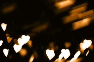 borroso luces en un oscuro antecedentes. festivo bokeh antecedentes en el formar de corazones para San Valentín día. suave enfocar. foto