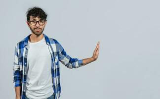 Displeased young man rejecting with rejection gesture, throw palms isolated. Displeased person with rejection gesture isolated, pulls palms in rejection, frowns in disgust photo