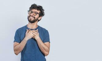 Grateful people smiling with hands on chest. Positive looking friendly handsome man with charming sincere smile feeling thankful, relaxed person with thanks gesture with hands on chest. photo