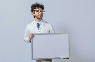 Professor in white coat holding small blank blackboard isolated. Scientist in glasses in a white coat is holding a blank whiteboard. Scientist showing blank whiteboard concept photo