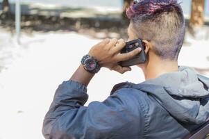 Close up of a man sitting on a bench calling on the phone, close up of a young man close up of a young man calling on the phone sitting on a bench photo