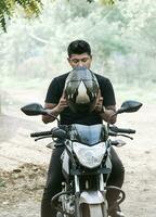 Man on motorcycle putting on helmet, motorcyclist putting on safety helmet, person on motorcycle putting on safety helmet photo