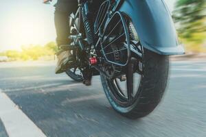 bajo ángulo ver de un motociclista montando motocicleta. cerca arriba de motociclista pies en su moto. bajo ángulo ver de un motorista conducción su moto foto