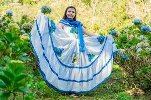 People in Nicaraguan national folk costume. Young Nicaraguan woman in traditional folk costume in a field of Milflores, Smiling woman in national folk costume in a field surrounded by flowers photo